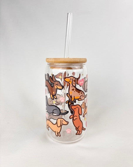 Clear tumbler with dachshund illustrations and a wooden lid on a white background