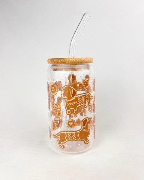 Clear tumbler with brown dachshund gingerbread illustrations and a wooden lid